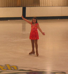 Skater in an orange dress on the ice