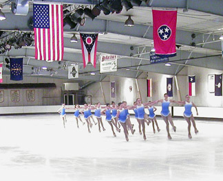 Synchro team in costume peforming on the ice