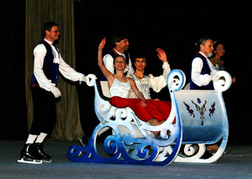 Sleigh being pulled by coach men with prince and princess waving
