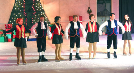 Adult skaters taking their bows in a line, linked together by holding their hands