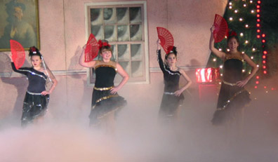 Four spanish dancers starting the number with their fans in front of their faces, with a cloud of smoke at their feet