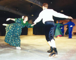 A waltzer holds his partner as she does an arabesque