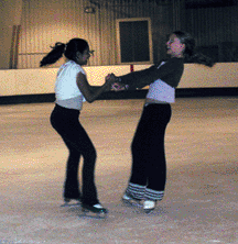  2 skaters in a pairs spin facing each other