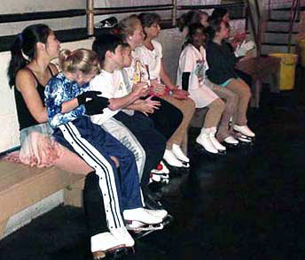 Skaters seated and watching from the bench