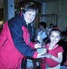 Shawnda and young skater are holding the eagle trophy