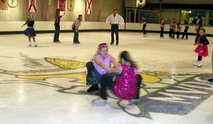 fun on ice, two skaters are doing a low spin