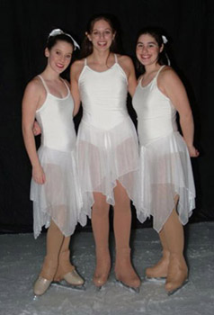 Three skaters in snowflake costumes