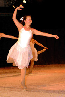 One skater poses as a snowflake in an arabesque